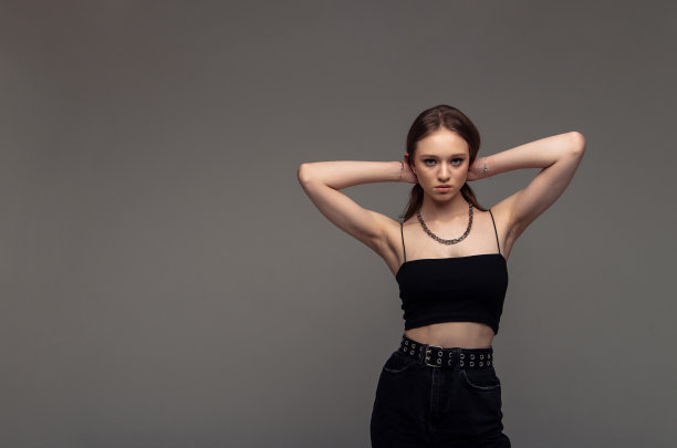 金发美女，穿着随意，满意地看着镜头，很开心。工作室拍摄的好看美丽的女人对空白工作室墙壁。图片下载