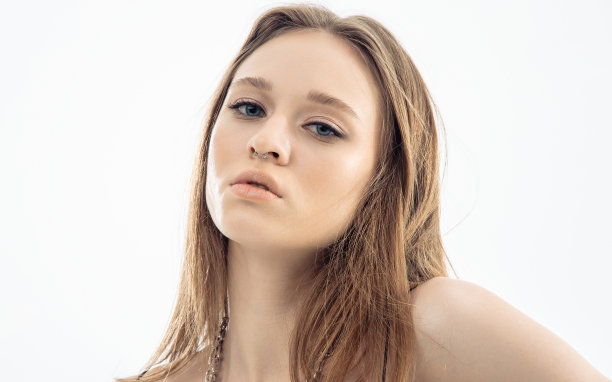 肖像美丽的模型在工作室灰色背景摆姿势。高加索人肖像的女人。图片下载