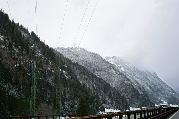 雪山悬崖和多云天空的自然景观，从布伦内罗高速公路到因斯布鲁克的交通视图图片下载