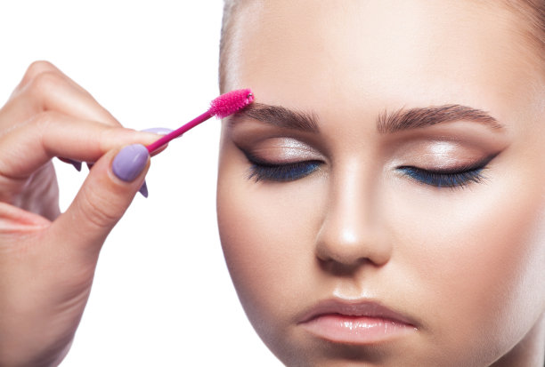 化妆师在美容院梳头和拔眉毛。专业护肤彩妆。图片下载