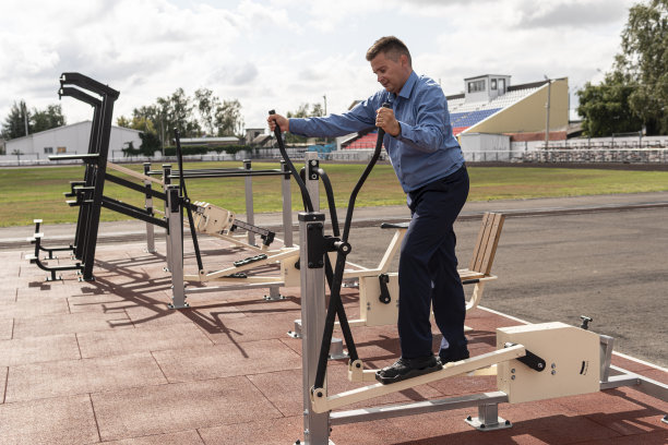一个商人在体育馆做运动。一个穿着西装的男人在体育馆的模拟器上热身。下班后的体育锻炼。与超重的斗争。图片下载