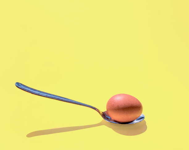 阳光下的鸡蛋和金属勺图片下载