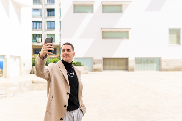 一名年轻的混血男子在城市里用智能手机自拍。社交媒体，沟通，移动应用，商业，生活理念图片下载