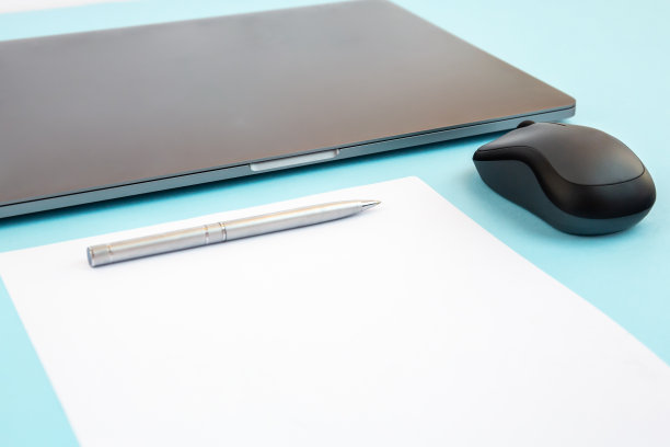 最小的办公桌与笔记本电脑，空白页与复印空间，笔，蓝牙鼠标。办公室模型，空文档。图片下载