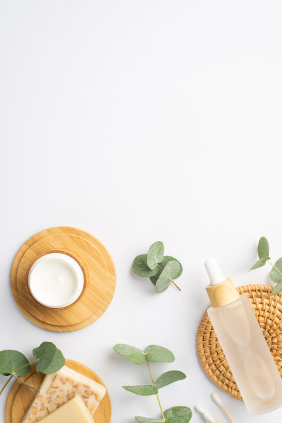 顶视图垂直照片的透明瓶液体棉花芽奶油瓶肥皂在木制的立场和桉树在孤立的白色背景与空白图片下载