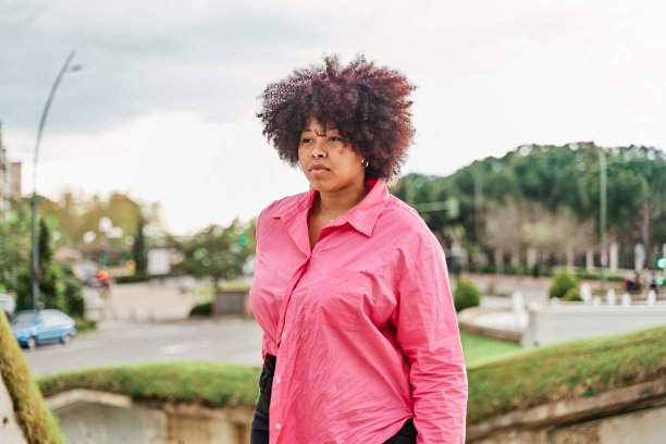 一个年轻女子的肖像与卷发的背景城市图片下载