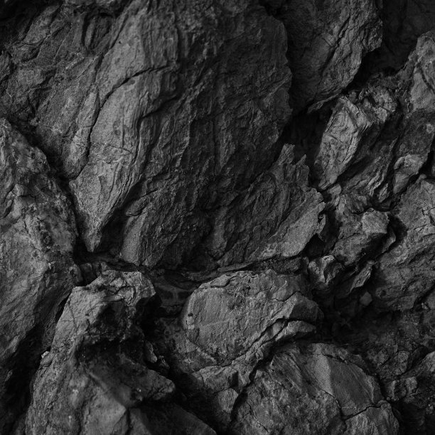 黑白色岩石纹理。粗糙的表面。特写镜头。黑色体量的石头背景与设计空间。崩溃了。风化。图片下载