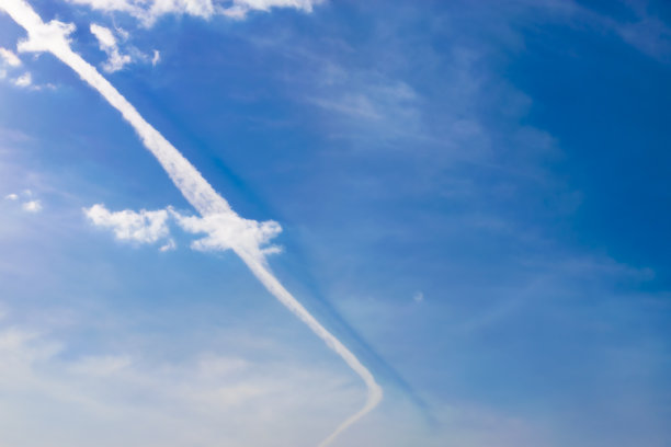 天空中云层中飞机的痕迹。图片下载