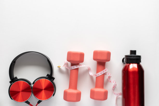白色背景下的卷尺、哑铃、水瓶和耳机。健身，运动和锻炼的概念与拷贝空间平坦图片下载