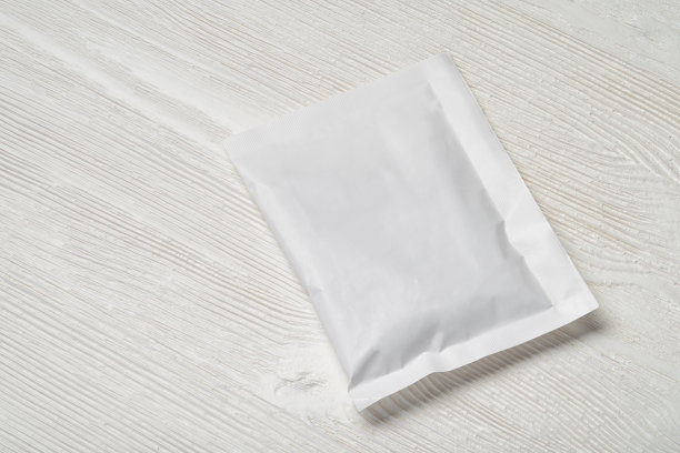 白色的纸包放在木桌上。图片下载