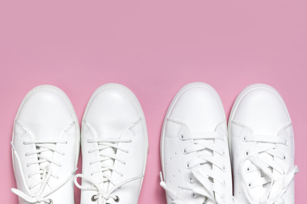白色妇女的皮革运动鞋在粉红色背景顶视图平lay。时尚青年运动鞋，运动鞋，真皮鞋履。简约的鞋店广告时尚风格的鞋子背景图片下载
