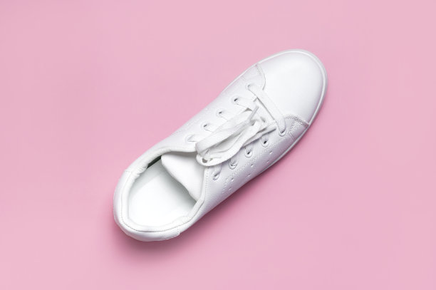 白色妇女的皮革运动鞋在粉红色背景顶视图平lay。时尚青年运动鞋，运动鞋，真皮鞋履。简约的鞋店广告时尚风格的鞋子背景图片下载