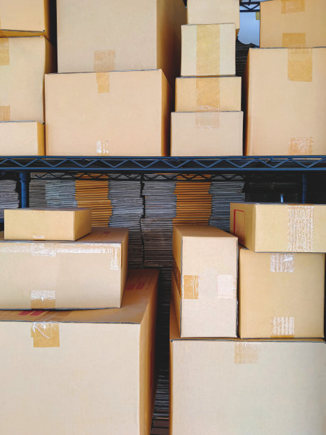 各种尺寸的许多纸板箱与堆叠折叠纸板箱在货架上出售的商店图片下载