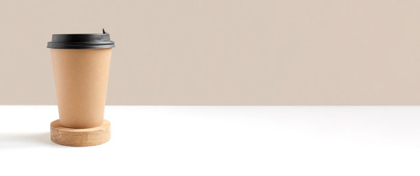 一个棕色的咖啡纸杯。与控制模型。套工艺纸杯咖啡或茶的米色背景。前视图。零浪费，无塑料的概念。一次性回收的杯子。图片下载
