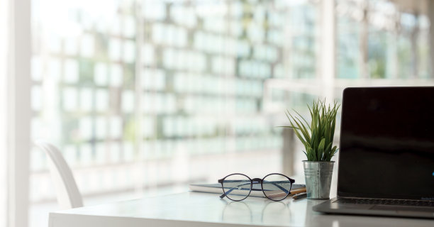 笔记本电脑或笔记本电脑黑屏在服务台模糊的背景与包裹快递办公室快递，EMS。图片下载