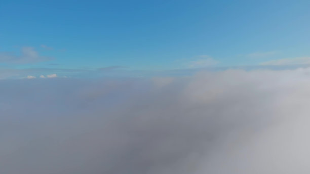 天上的云向太阳飞去，蓝色的天空布满了松软的云朵，被明亮的阳光照射着。乘飞机飞越白云，乘飞机度假。图片下载