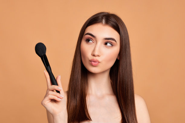 拿着化妆刷的漂亮年轻女子图片下载