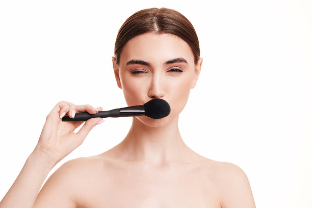 年轻漂亮的女人用化妆刷刷粉图片下载
