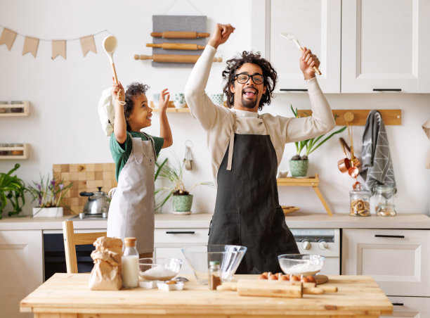 黑人父亲和男孩在厨房做饭时玩得很开心图片下载