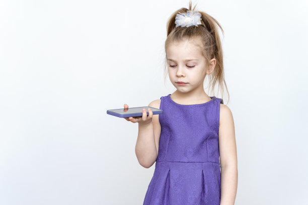 一个可爱的5岁女孩的肖像与智能手机图片下载