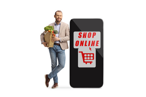 一名年轻男子的全长肖像，拿着一个购物袋，倚靠在智能手机上，在网上购物图片下载