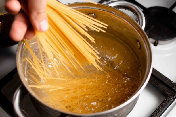 将意大利面浸入平底锅的沸水中。面食烹饪。图片下载