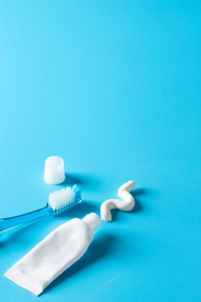 蓝色的牙刷和牙膏管在蓝色的背景。基本牙科保健口腔健康的概念。本空间图片下载
