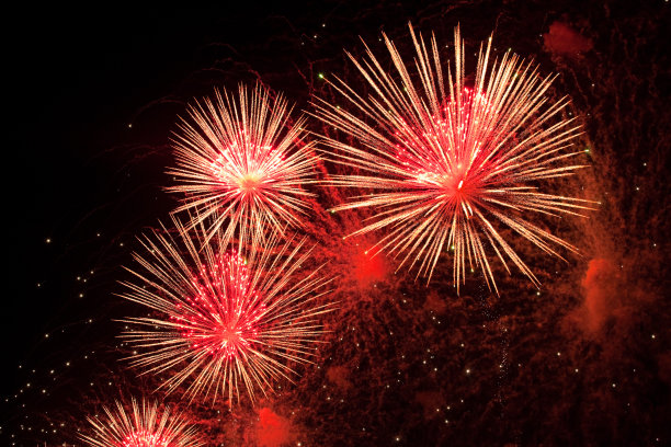 红色、粉色和金色的烟花火花在天空中爆炸，炸药冒出浓烟图片下载