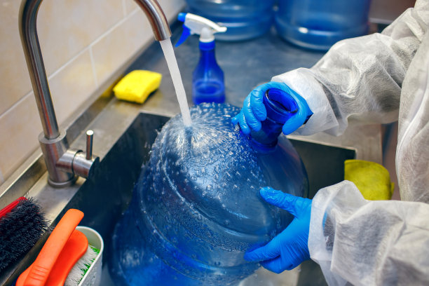 工厂工人在水压下清洗一个大塑料瓶图片下载