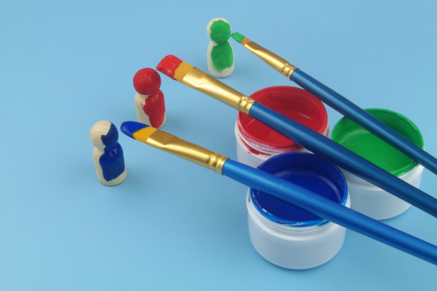 木制的人，人物和不同的画笔与油漆接近。图片下载