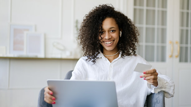 非洲裔美国女孩使用笔记本电脑在家里用信用卡在线购物图片下载