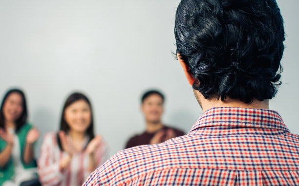 选择性聚焦前景企业的男教练做车间或研讨会，培训观众在室内办公室，会议室与背景模糊的人。图片下载