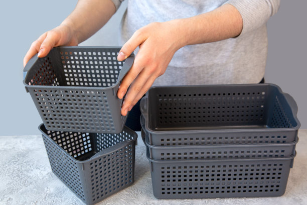 这个女孩用灰色的塑料盒子来储存东西。家庭空间的组织，家庭秩序。图片下载