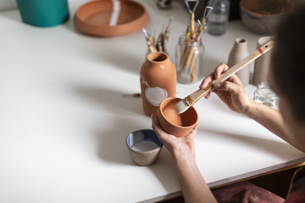 陶艺家在画室里给陶瓶作画图片下载
