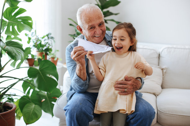 爷爷和孙女在家里玩玩具飞机图片下载