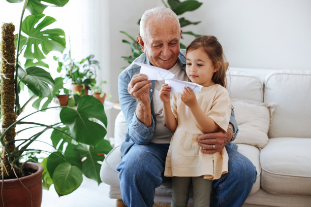 爷爷和孙女在家里玩玩具飞机图片下载