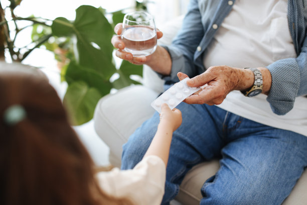 小女孩正在给她生病的老祖父开药图片下载