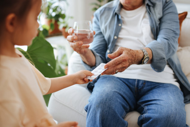 小女孩正在给她生病的老祖父开药图片下载