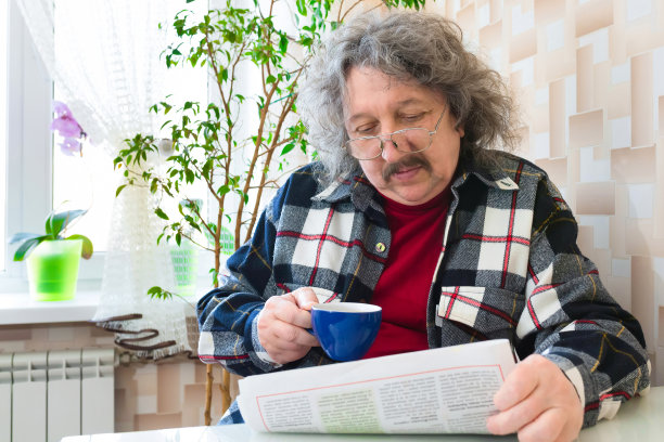 一位老人在家喝茶，看早间新闻。图片下载