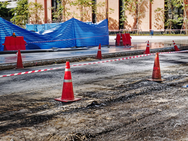 建筑工地道路两旁的橙色道路锥图片下载
