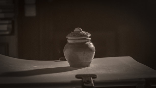 照相馆里一个旧陶罐的深褐色照片。用照相机训练射击的投手。空间的文本。图片下载