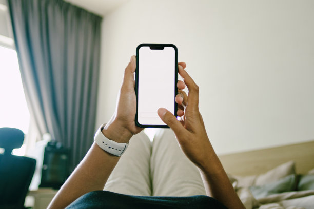 年轻女子躺在家里的床上使用智能手机图片下载