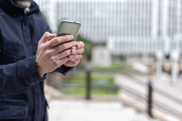 一名男性高管在金融区使用手机。寒冷的冬天环境图片下载