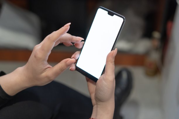 一名年轻女子手里拿着一个带有白色屏幕的手机，特写镜头图片下载