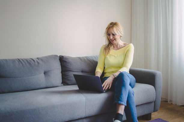 一个成熟的女人用她的笔记本电脑看视频图片下载