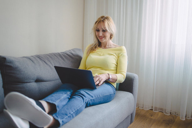 一个成熟的女人用她的笔记本电脑看视频图片下载