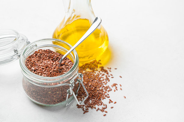 灰色背景上有亚麻籽和亚麻籽油。图片下载