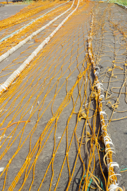 橙色的渔网伸展在港口码头。图片下载