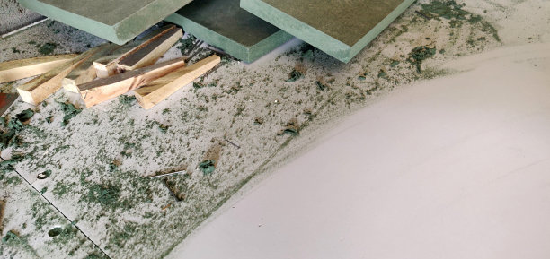 正在进行的工作-一个木匠的工作区，绿色的木板或木板杂乱地散落在工作台上或长凳上，有文本的复制空间图片下载