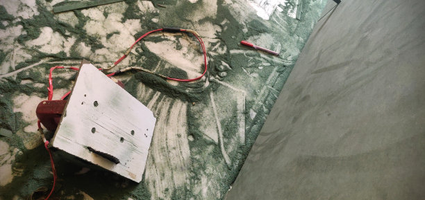 正在进行中的工作——木匠在建筑工地用圆锯机、笔、绿色木板、凌乱地散落着的锯末进行的工作图片下载